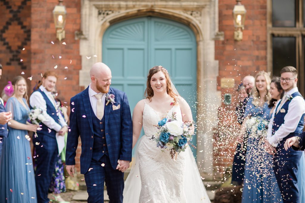 wedding photography at hodsock priory. The bride and groom having confetti thrown on them on their wedding day.