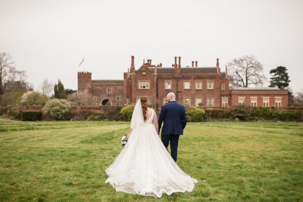 wedding photography at hodsock priory. The bride and groom walking together towards hodsock priory.